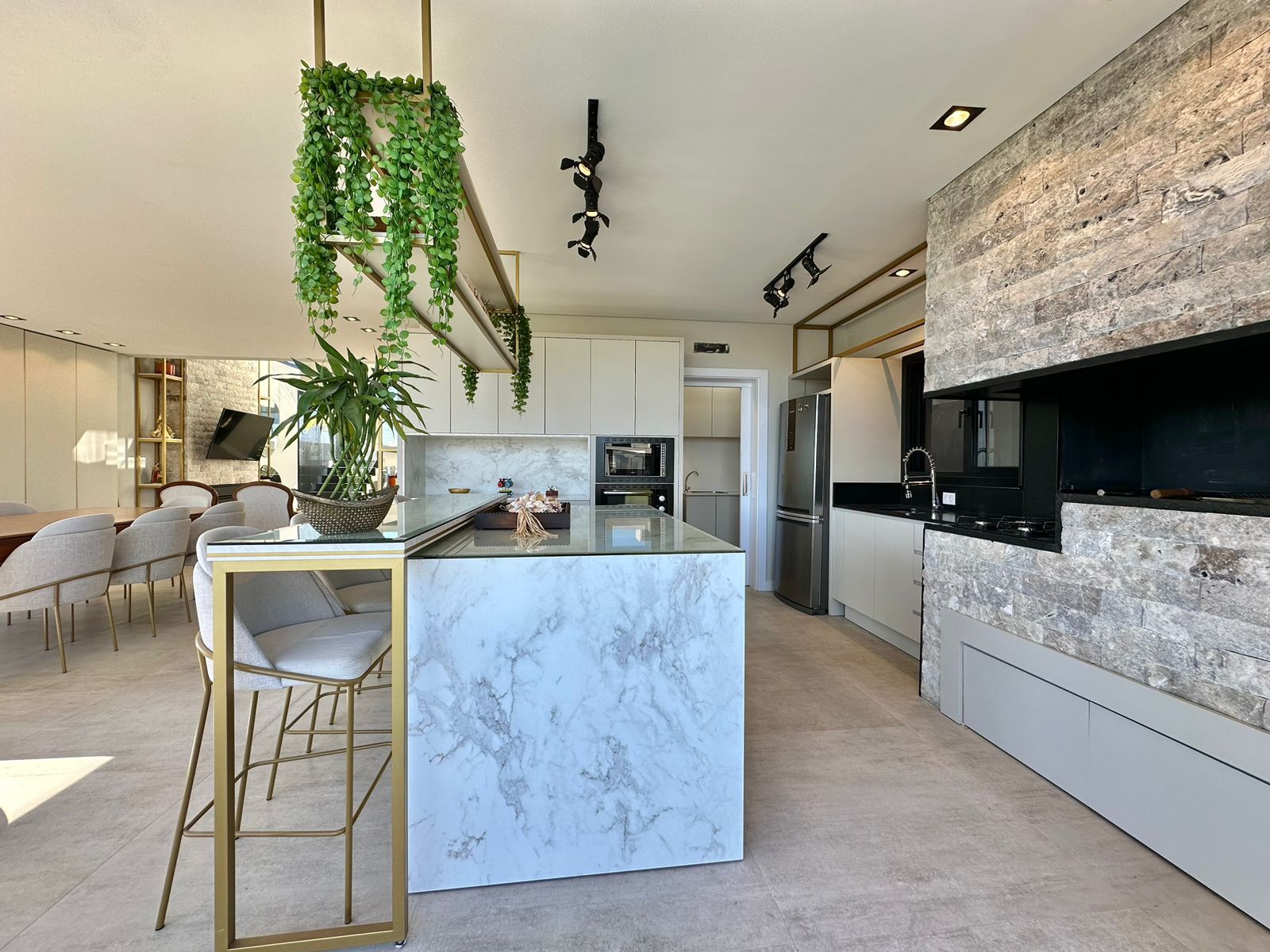 Cozinha integrada com bancada de mármore e parede de fundo em Rock Face Travertino Silver