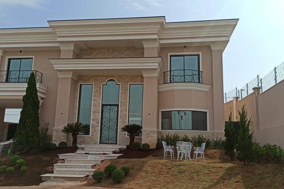 Fachada de mansão com colunas e base revestidas em rock face travertino claro