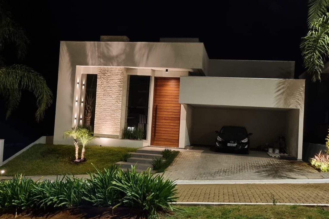 Fachada iluminada à noite com painel em Rock Face Travertino Romano Light