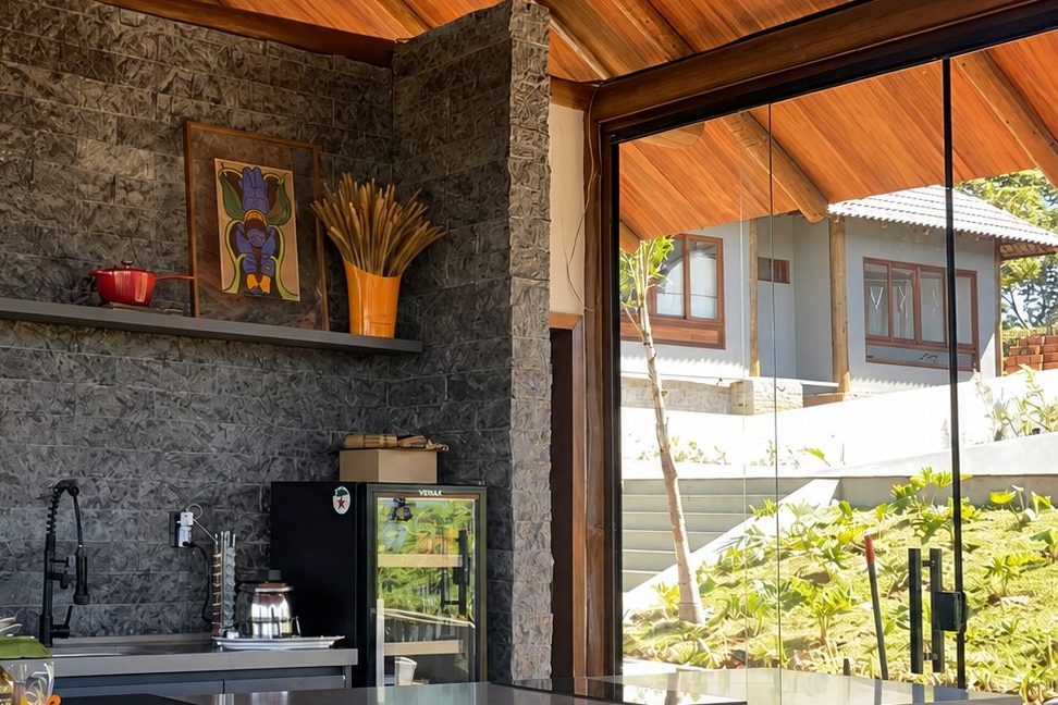 Varanda gourmet com parede em Rock Face Matrix e cobertura de madeira