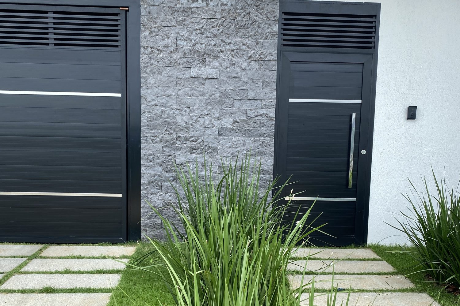 Entrada de casa com painel de Rock Face Matrix entre os portões
